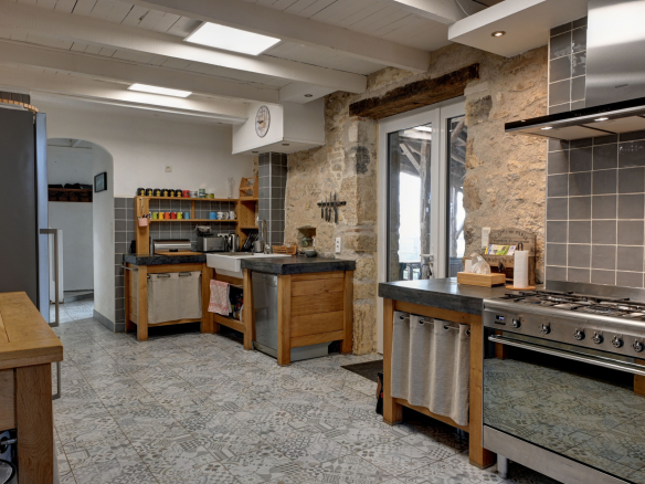Kitchen in a stone house with antique features and modern equipment.