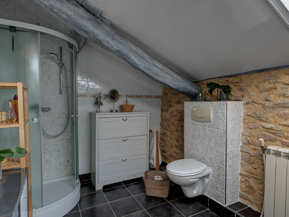 Modern bathroom with shower, sink and toilet in a stone estate.