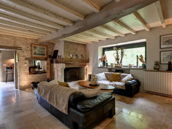 Interior of a house with a comfortable living room, leather sofa and stone fireplace.