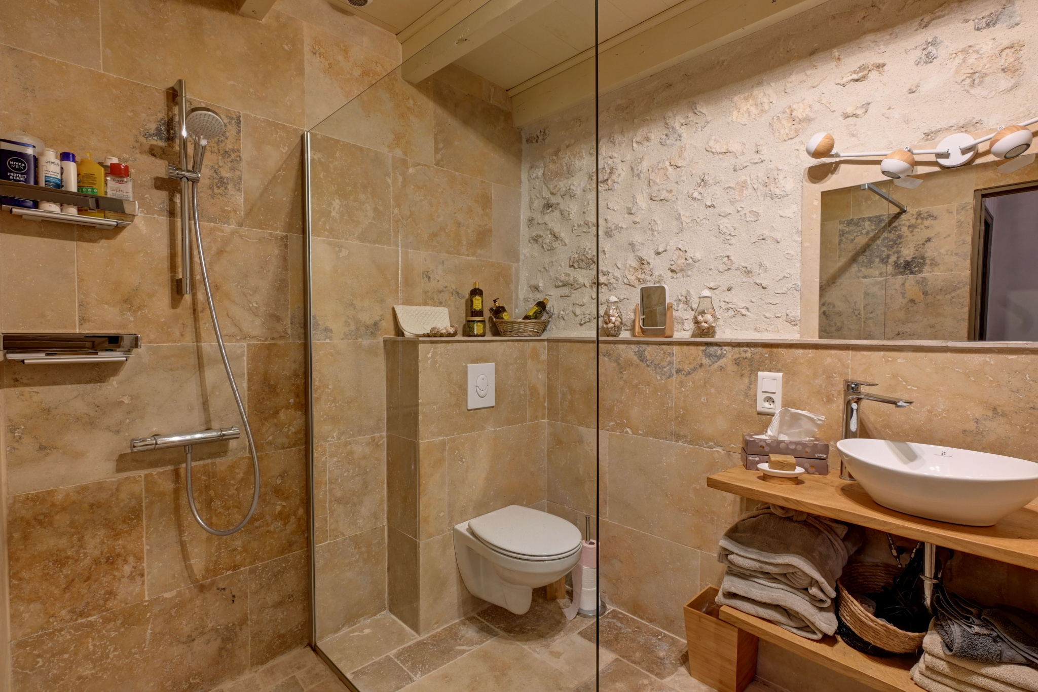 Elegant bathroom Modern bathroom with shower and sink, stone walls and beige tiles.