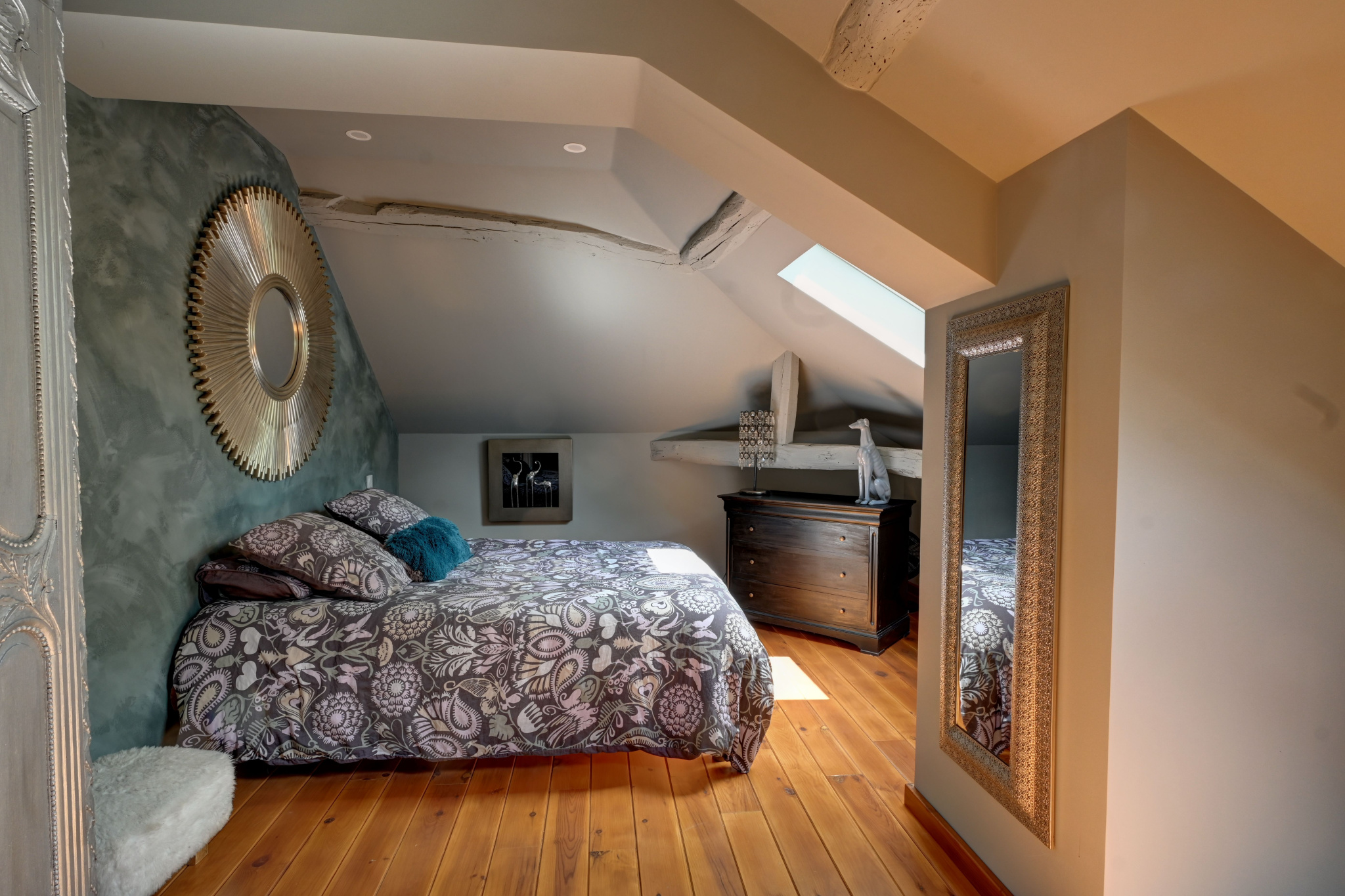 Room in a prestigious property in Saint-Beauzeil Elegant room with double bed, modern decor and mirror, under a sloping ceiling.