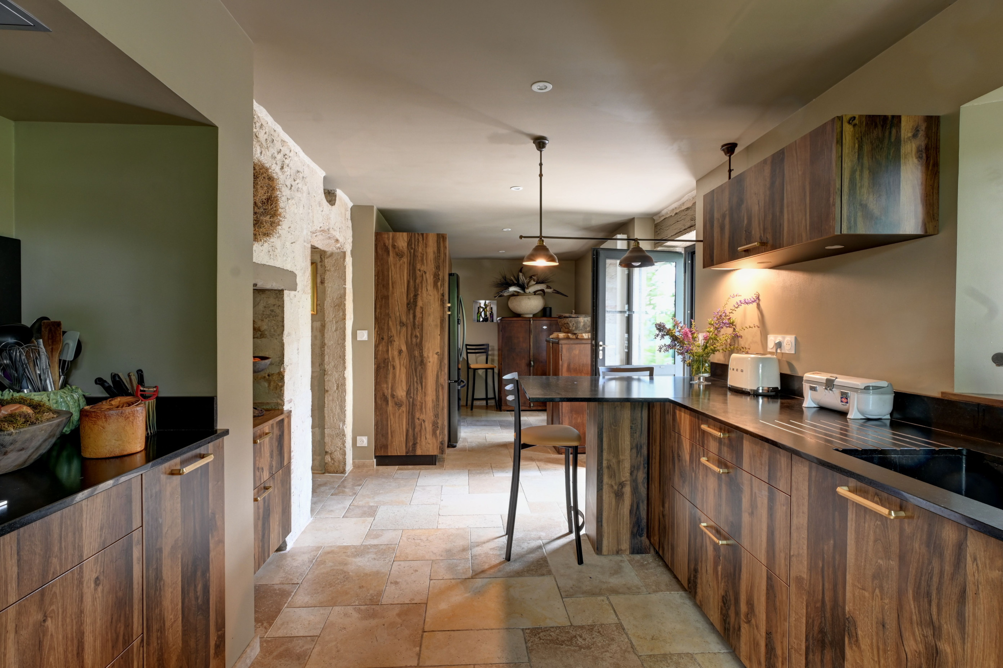 Main house kitchen Modern kitchen with wooden furniture and stone worktop in a renovated house.