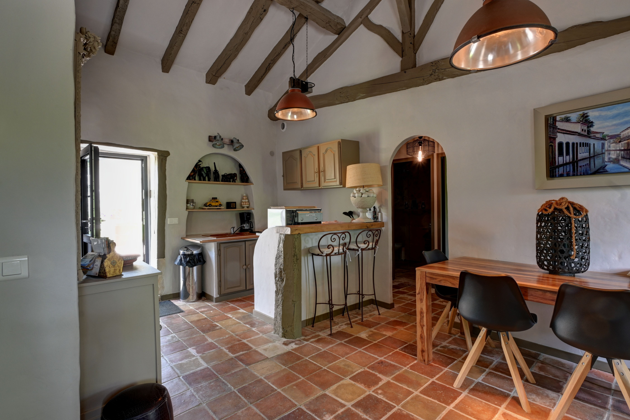 Interior of a prestigious house Interior of a house with open kitchen and dining room, stone walls and exposed beams.