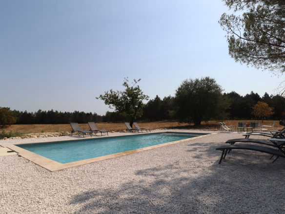 Piscine entourée de chaises longues dans une propriété de 13,5 hectares à Villeneuve-sur-Lot.