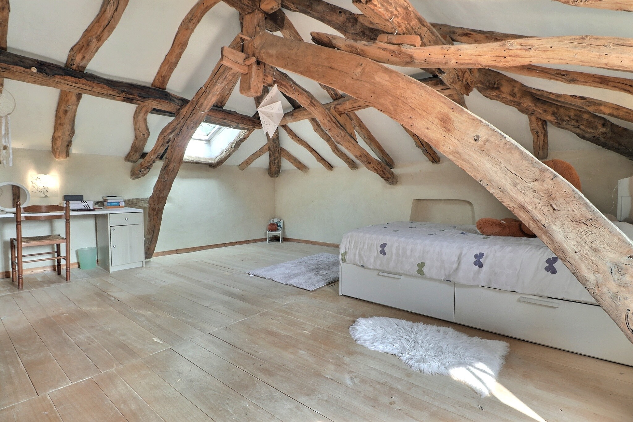 Chambre avec poutres apparentes Intérieur d'une chambre avec poutres apparentes et parquet en bois.