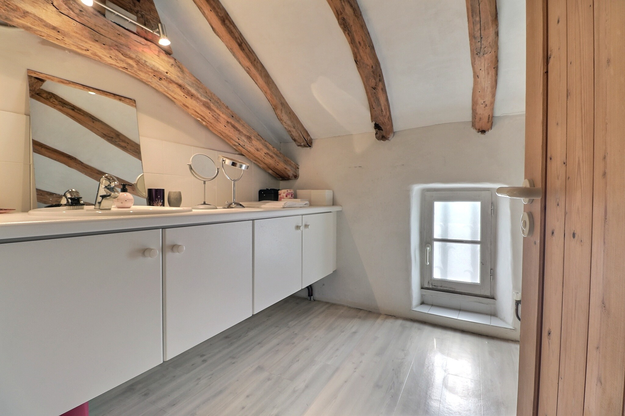 Intérieur d’une maison avec poutres apparentes Intérieur d'une maison avec des poutres apparentes et un meuble de salle de bain.