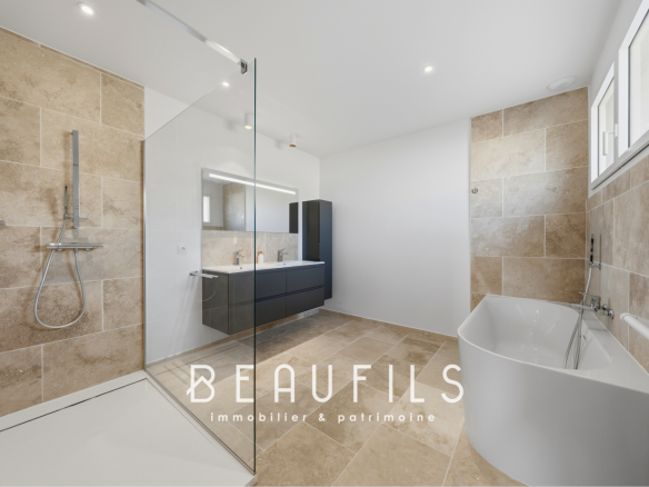 Salle de bain moderne avec douche à l'italienne et baignoire dans un mas historique.