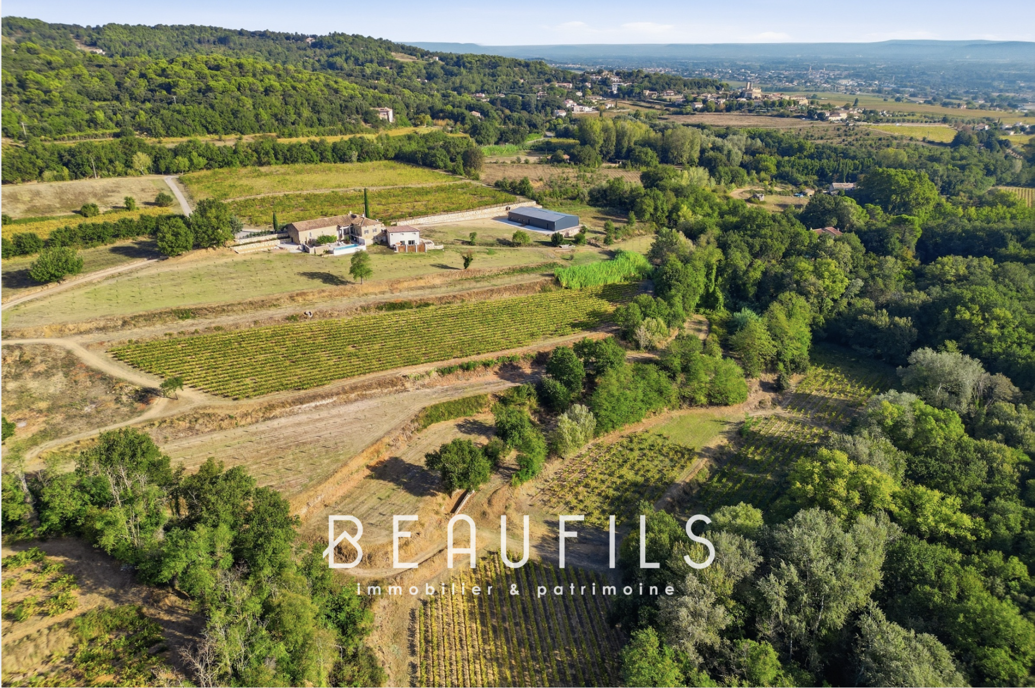 Domaine viticole près d’Orange Vue aérienne d'un domaine viticole avec un mas historique et des collines en arrière-plan près d'Orange.