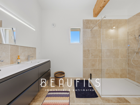 Salle de bain moderne avec douche et double vasque.