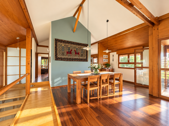 Intérieur d'une maison d'architecte avec salle à manger lumineuse et plafond cathédrale.