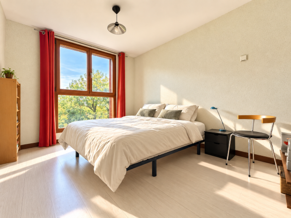 Chambre lumineuse avec lit double et fenêtre donnant sur la nature.