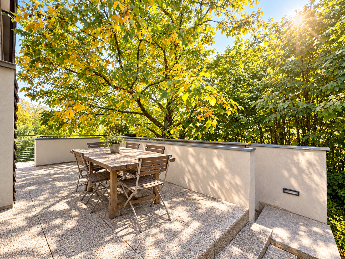 Terrasse d’une maison d’architecte à Péron Terrasse en bois avec table et chaises, entourée de verdure, à Péron.
