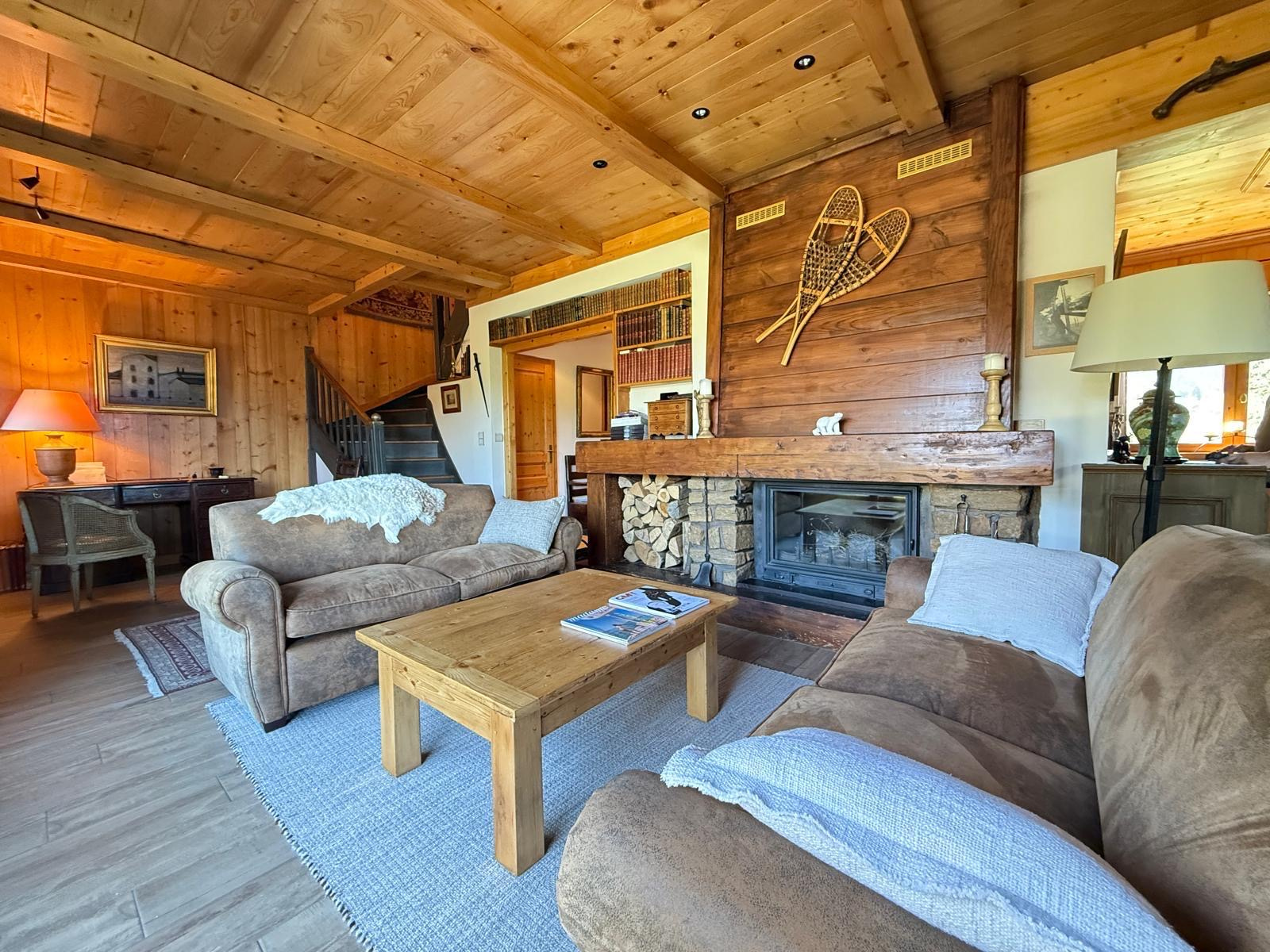 Intérieur d'un chalet en bois avec salon confortable, cheminée et décoration authentique.