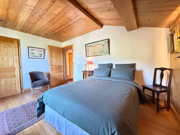Chambre d'un chalet en bois avec lit double et décoration chaleureuse.