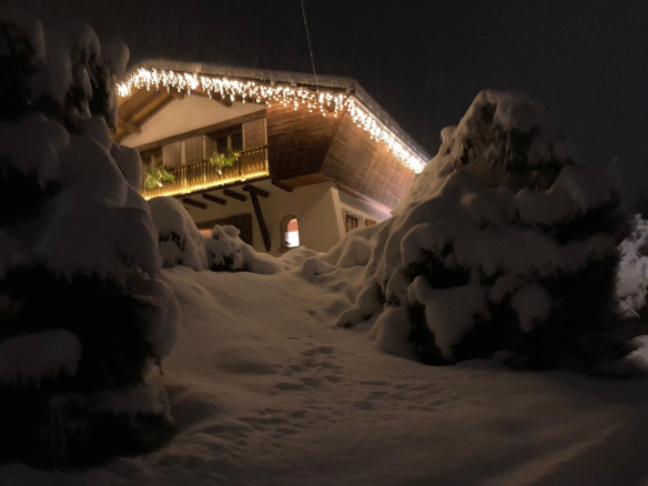 Chalet enneigé avec décorations lumineuses, entouré de neige à Cordon.