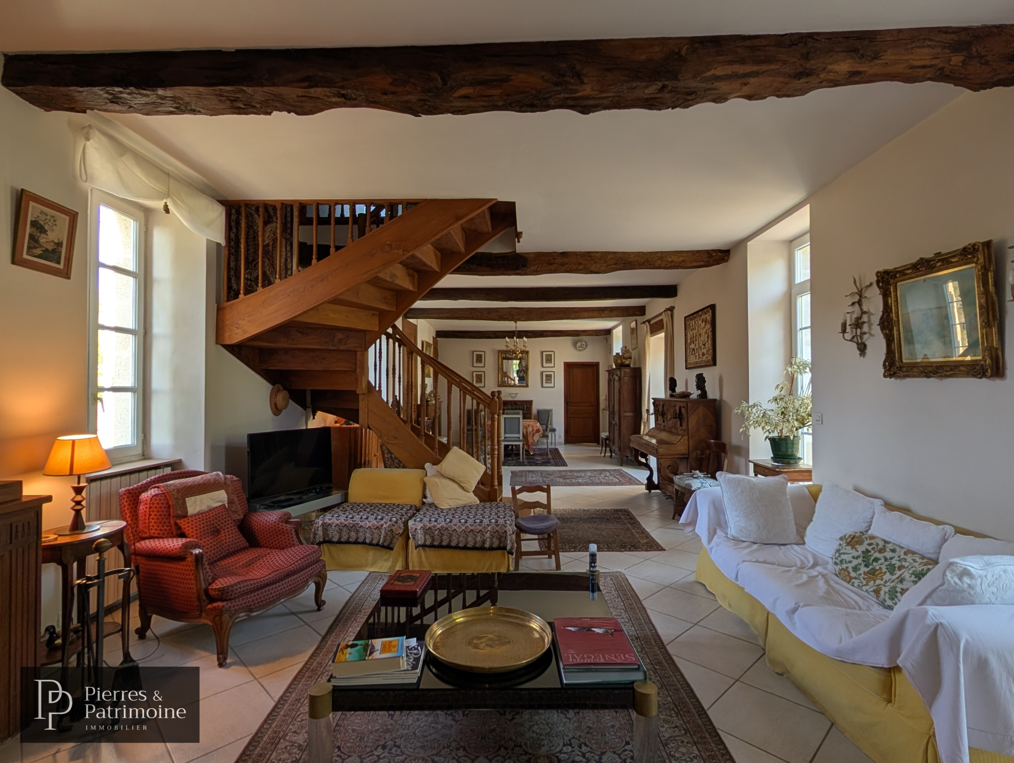 Intérieur d’une propriété de caractère à Nérac Intérieur d'une maison de caractère avec salon spacieux et escaliers en bois à Nérac.