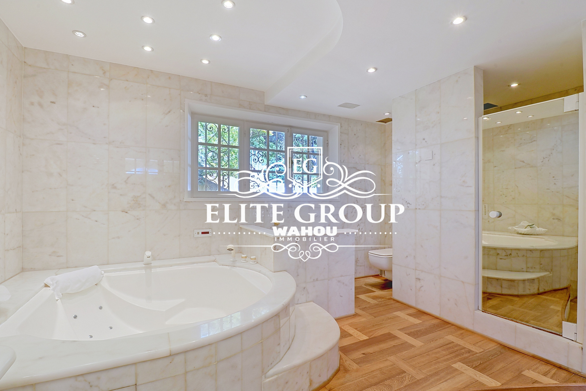 Salle de bain élégante dans une villa à Nice Salle de bain spacieuse avec baignoire et miroir, décorée en marbre.