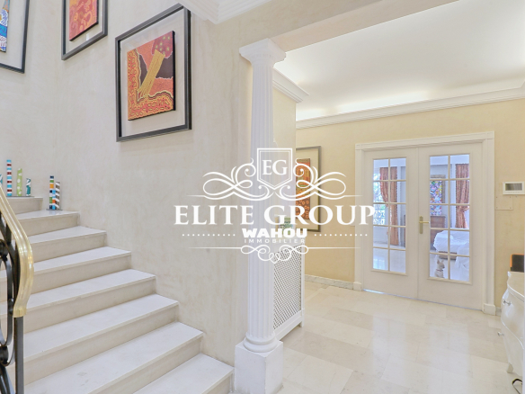 Intérieur d'une maison bourgeoise à Nice, avec un escalier et des œuvres d'art aux murs.