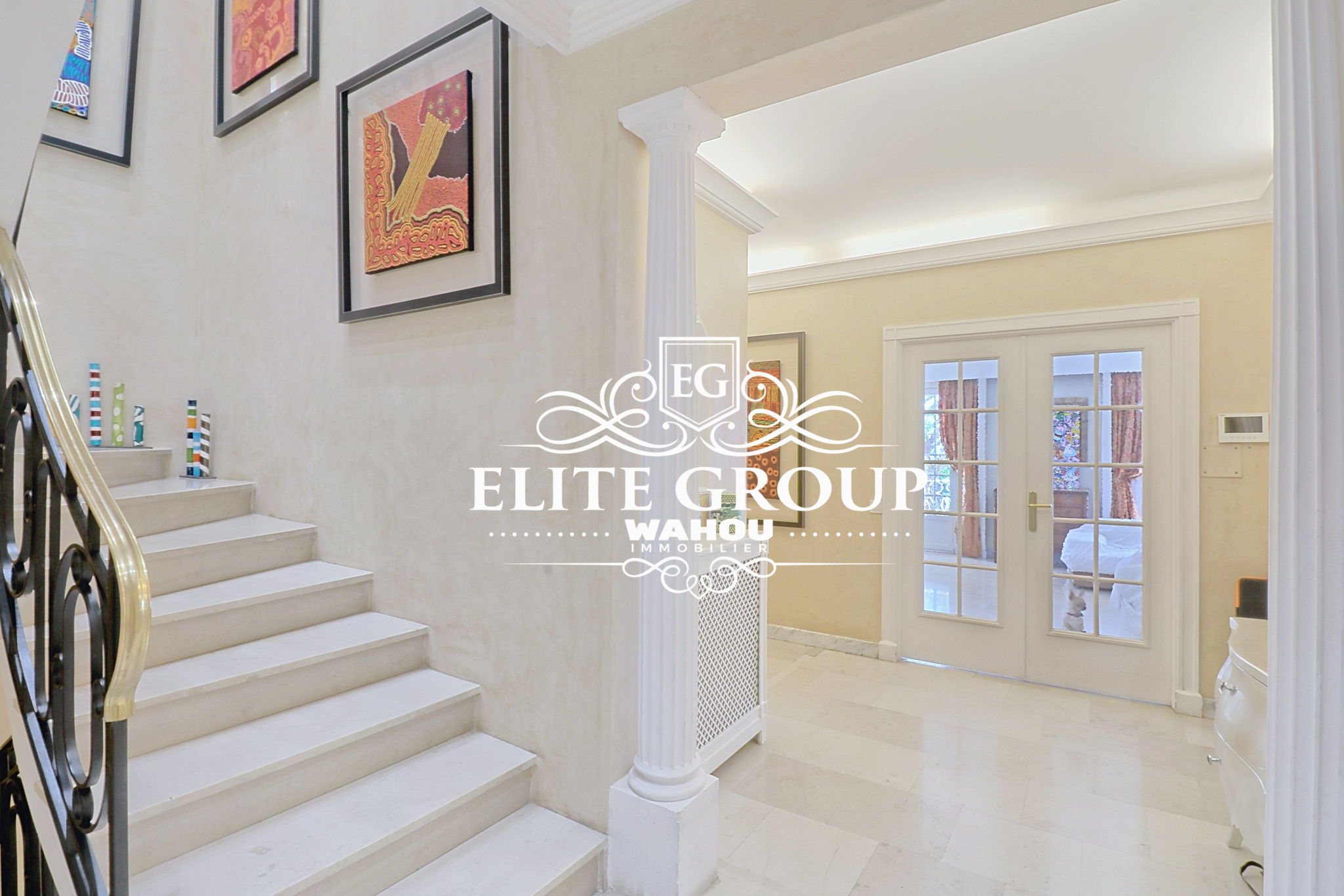 Intérieur d’une villa bourgeoise à Nice Intérieur d'une maison bourgeoise à Nice, avec un escalier et des œuvres d'art aux murs.