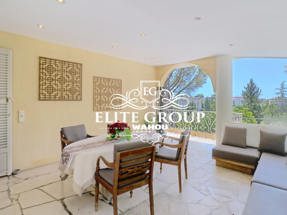 Terrasse d'une villa bourgeoise à Nice avec mobilier et vue sur le jardin.