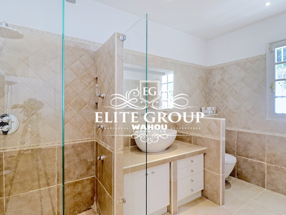 Salle de bain moderne avec douche en verre et meuble vasque dans une villa à Nice.