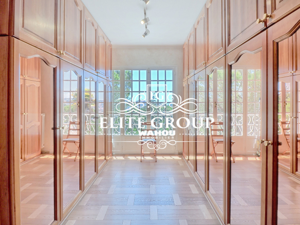 Intérieur d'une villa bourgeoise à Nice avec des placards en bois et de grandes fenêtres.