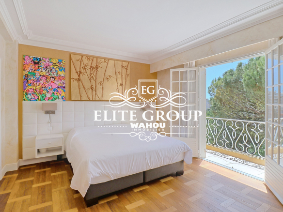 Chambre lumineuse avec balcon et vue sur la nature, dans une villa bourgeoise à Nice.