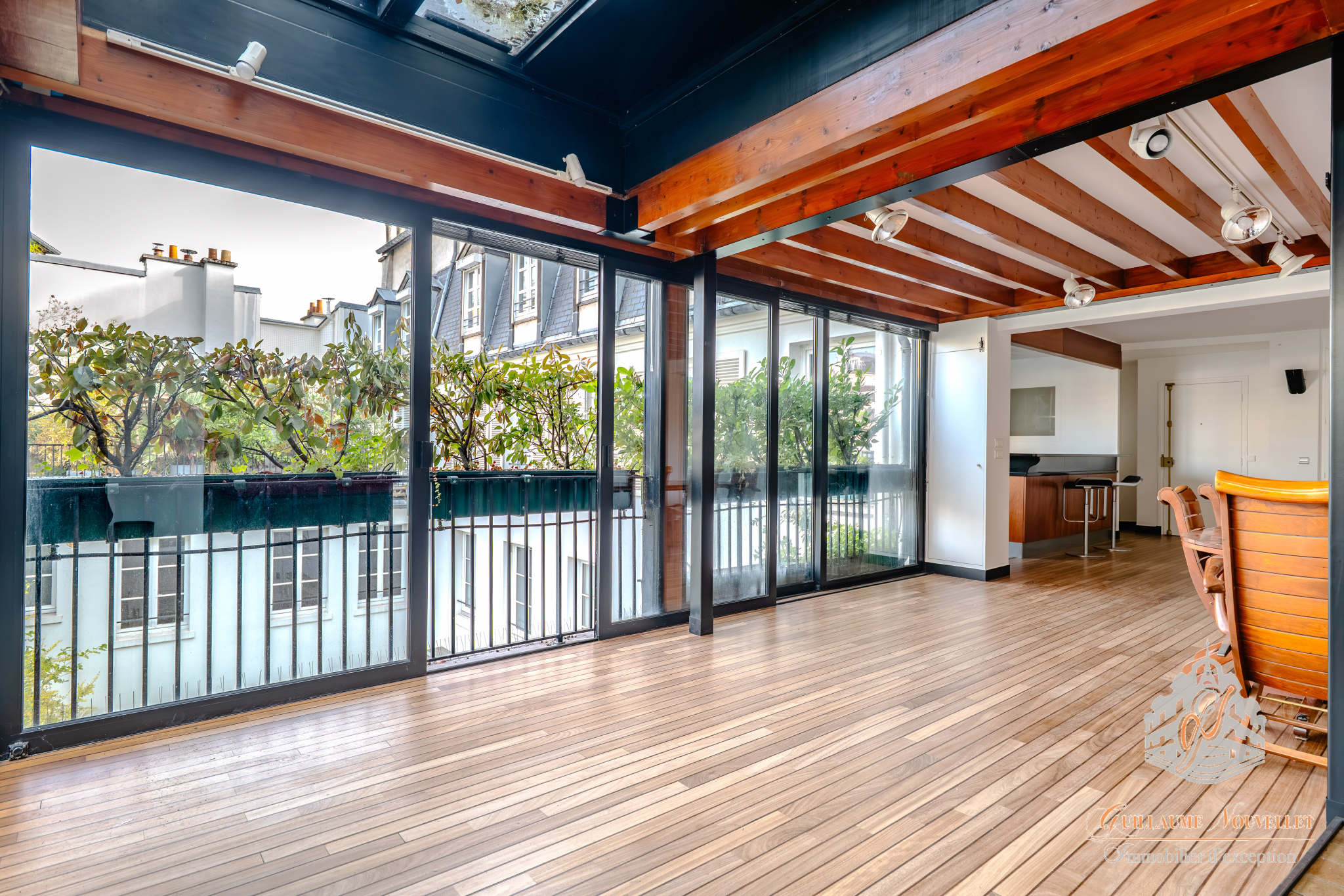 Intérieur d’un duplex à Paris Intérieur d'un duplex avec grandes baies vitrées et parquet, vue sur des terrasses végétalisées.