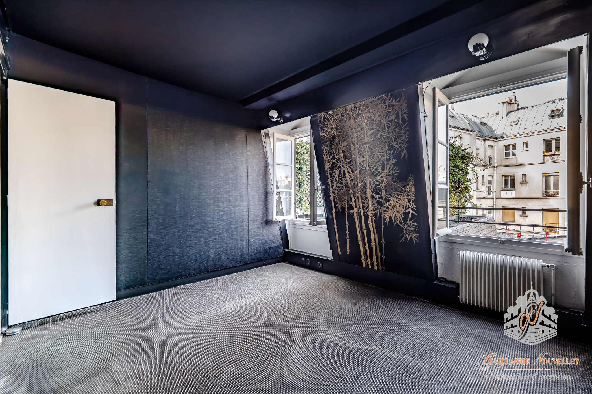 Intérieur d’un duplex à Paris Intérieur d'un duplex avec murs sombres et fenêtres ouvertes sur une vue extérieure à Paris.