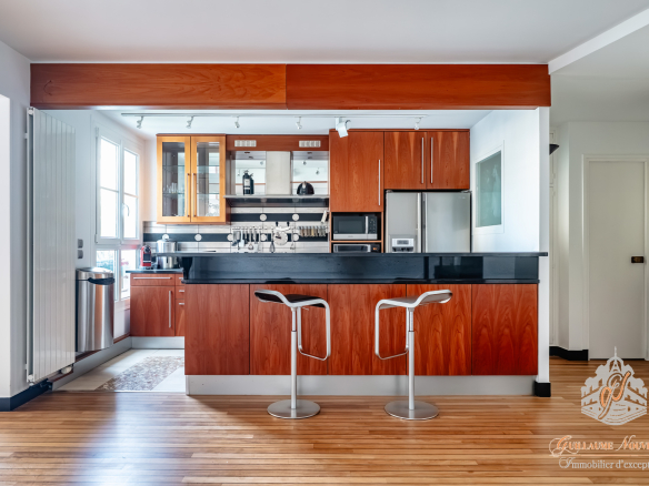 Cuisine moderne dans un duplex avec comptoir et bar, parquet en bois.