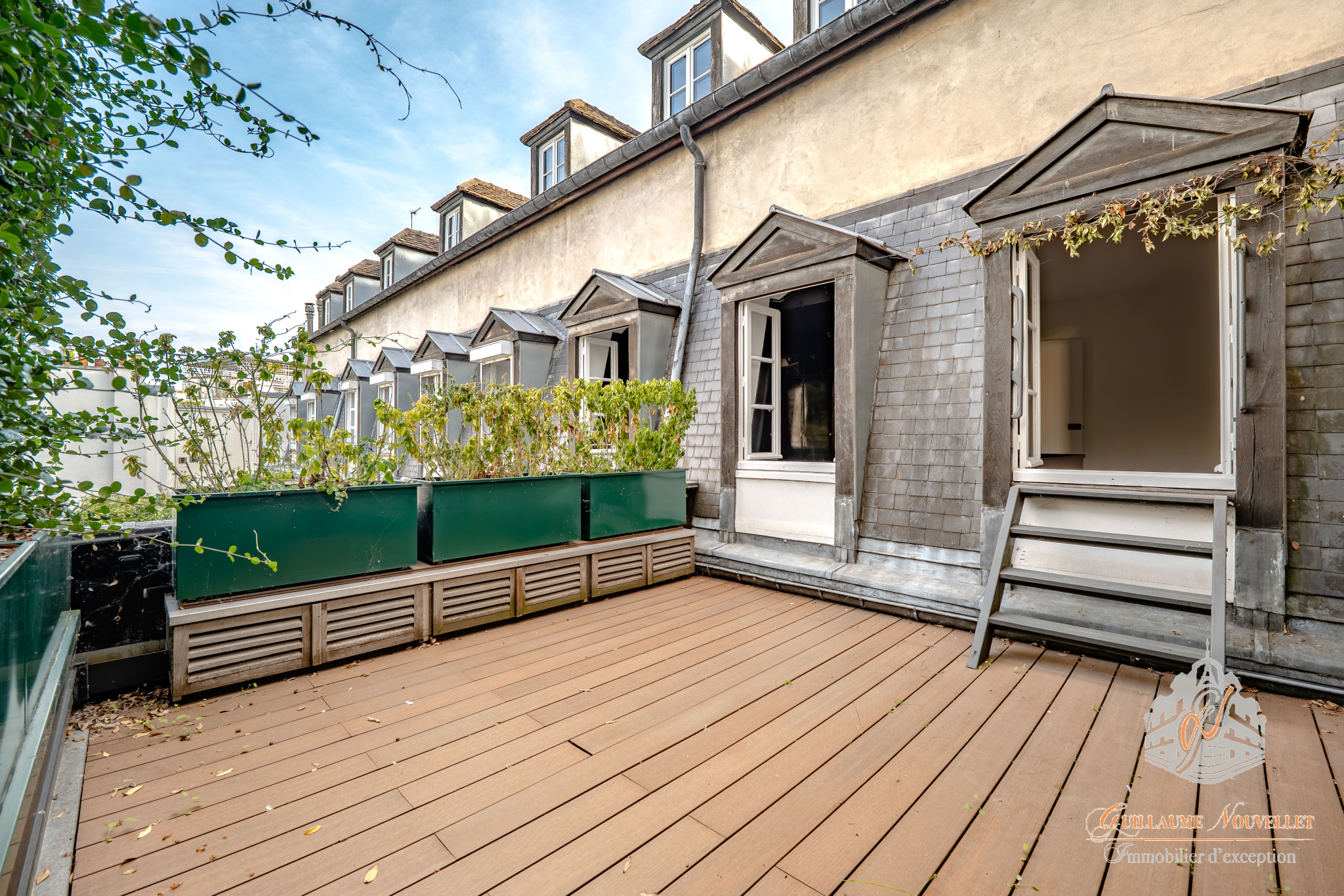 Terrasse d’un duplex à Paris Terrasse d'un duplex avec des structures en bois et des plantes, vue sur un immeuble parisien.