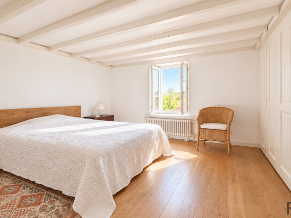 Chambre lumineuse avec lit double et fenêtre à Sergy.