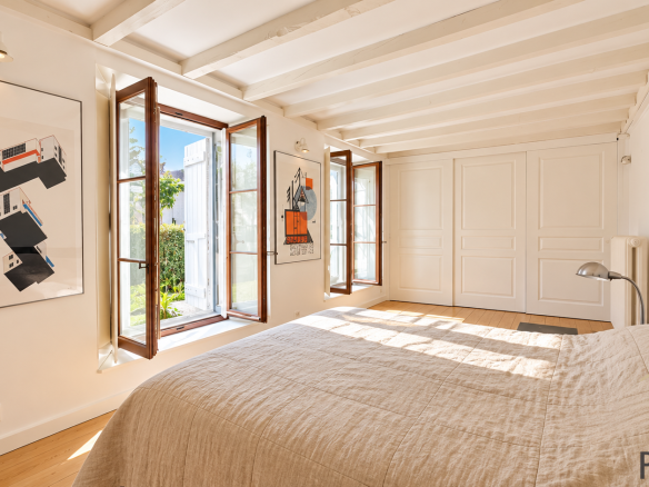 Chambre lumineuse avec fenêtres à battants et décoration moderne dans une maison en pierre à Sergy.