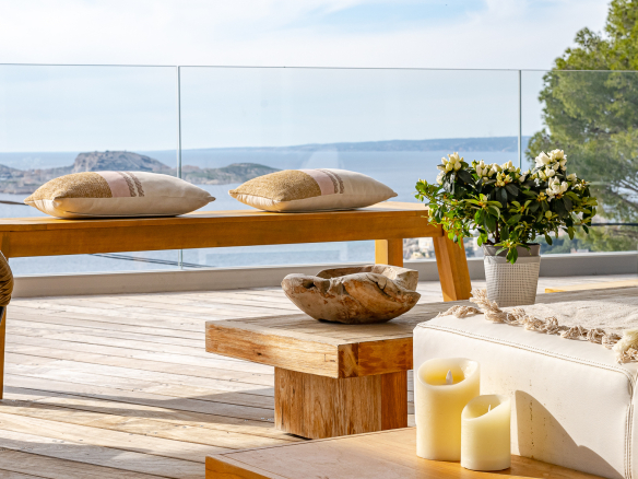 Terrace of a modern villa with sea view, wooden furniture and elegant decoration.