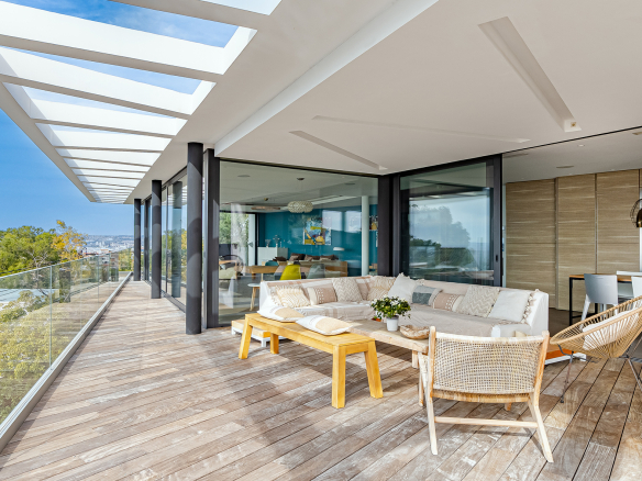 Modern terrace with wooden furniture and panoramic sea views in Marseille.