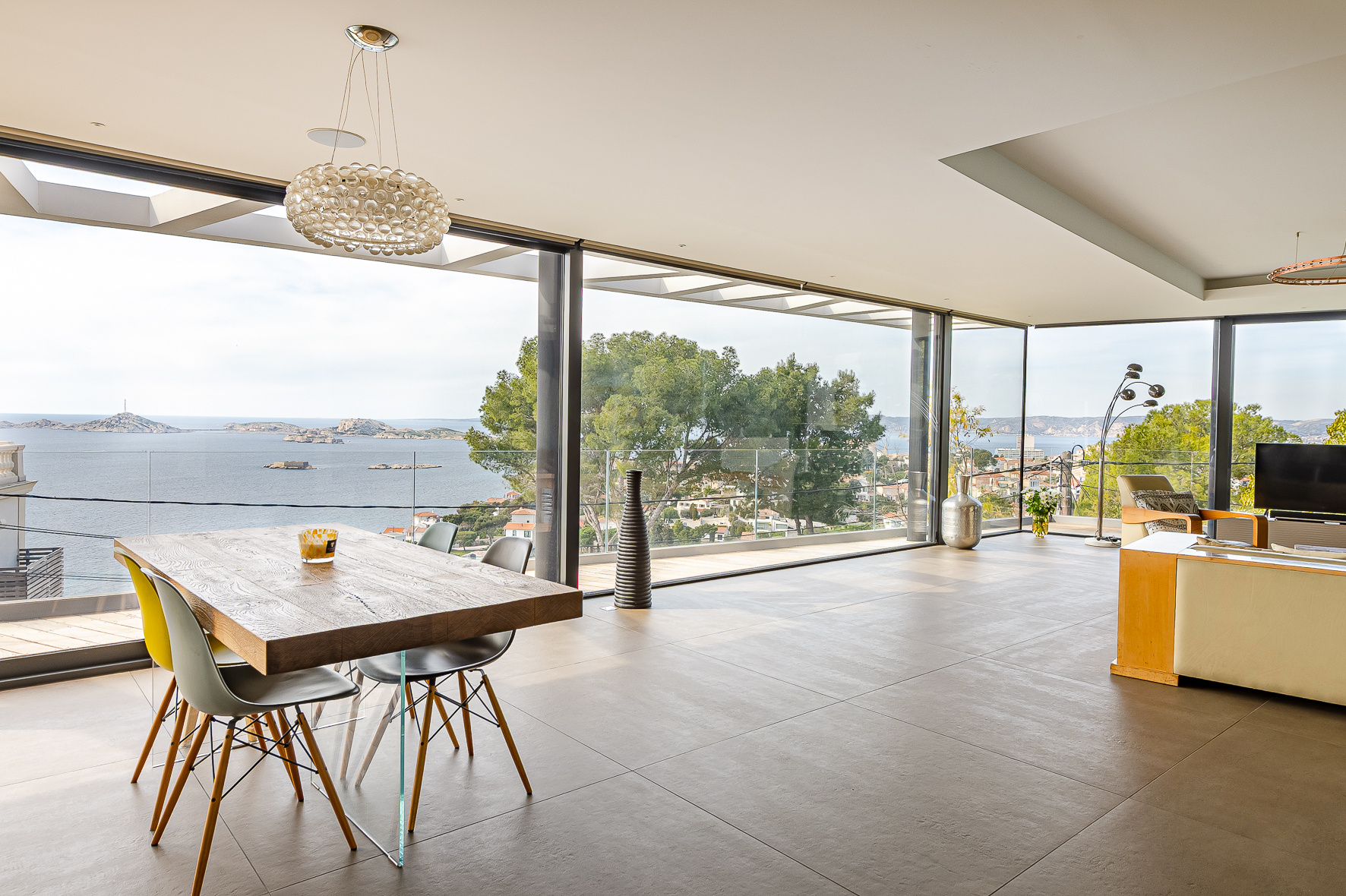 Interior of a contemporary villa in Marseille Modern interior of a villa with sea view, dining table and large bay windows.