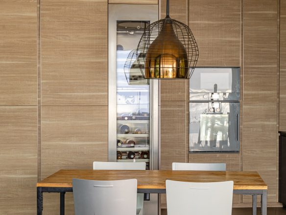 Modern kitchen interior with wooden table and white chairs, designer lighting.