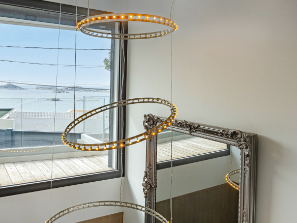 Modern interior with sea view, pendant lighting and decorative mirror.