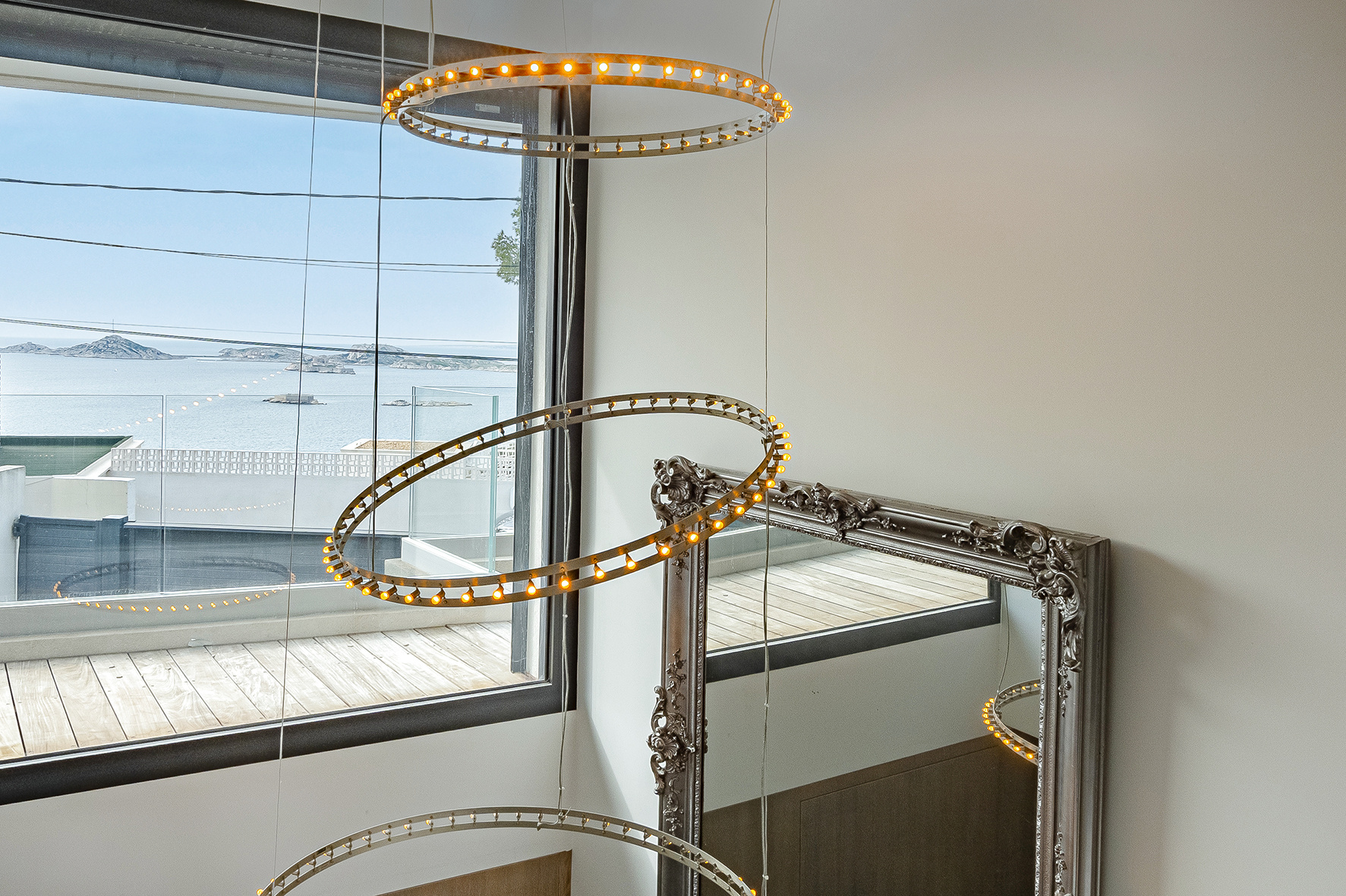 Interior of a contemporary villa in Marseille Modern interior with sea view, pendant lighting and decorative mirror.
