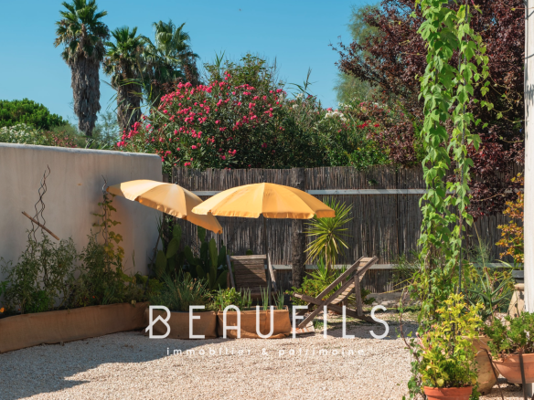 Terrace of a Mediterranean villa with sun loungers and parasols in Saintes Maries de la Mer.