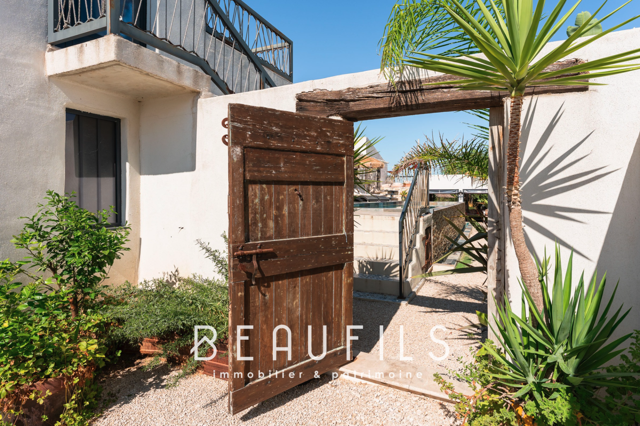 Entrance to a Mediterranean villa Entrance to a Mediterranean villa with a wooden door and plants, Saintes Maries de la Mer.