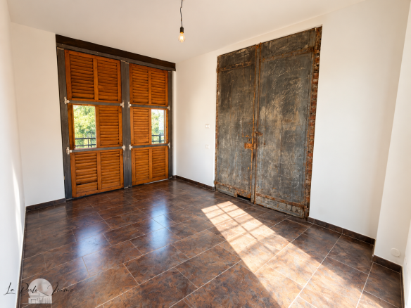 Interior of a room with wooden shutters and a tiled floor in Perpignan.