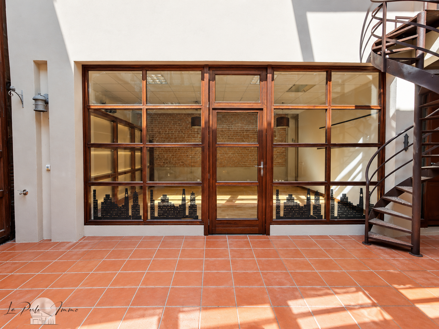 Former wine cellar renovated in Perpignan Interior of a renovated old wine cellar with brick walls and a large wooden window.