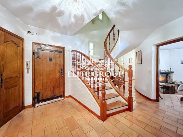 Interior of a Provençal villa with a wooden staircase and white walls in Mougins.