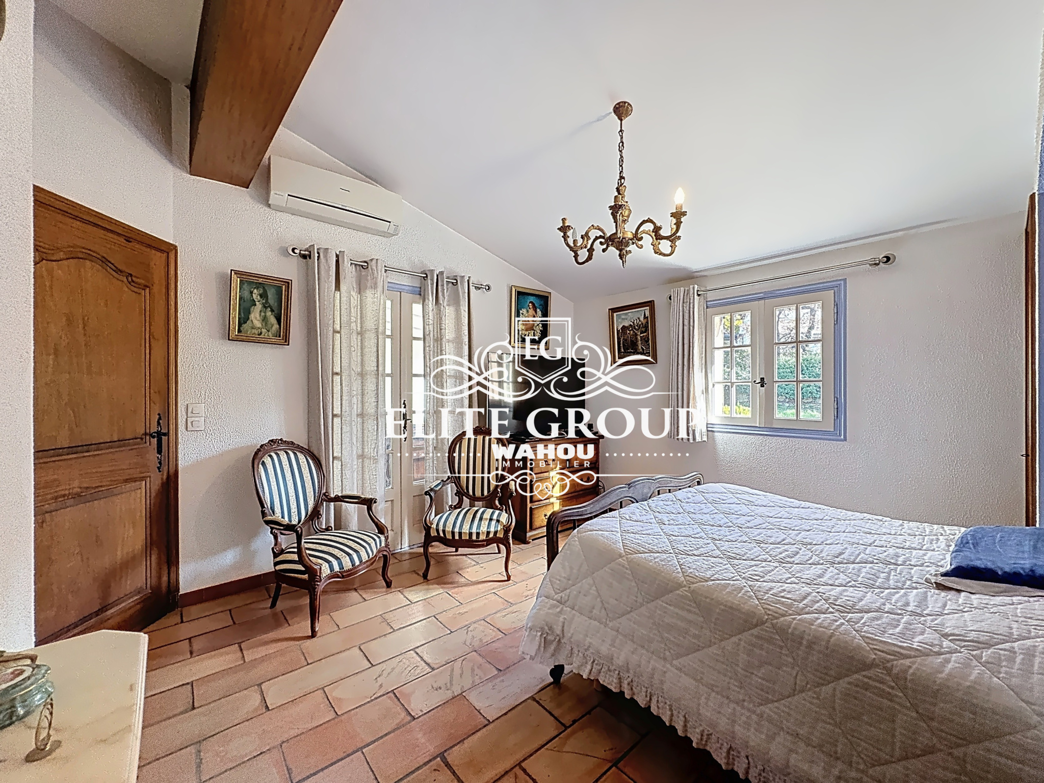 Bedroom in a Provençal villa in Mougins with wooden furniture and classic decor.