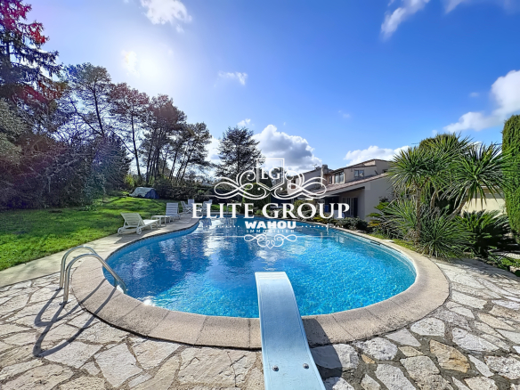 Provençal villa with swimming pool in Mougins, surrounded by greenery and palm trees.