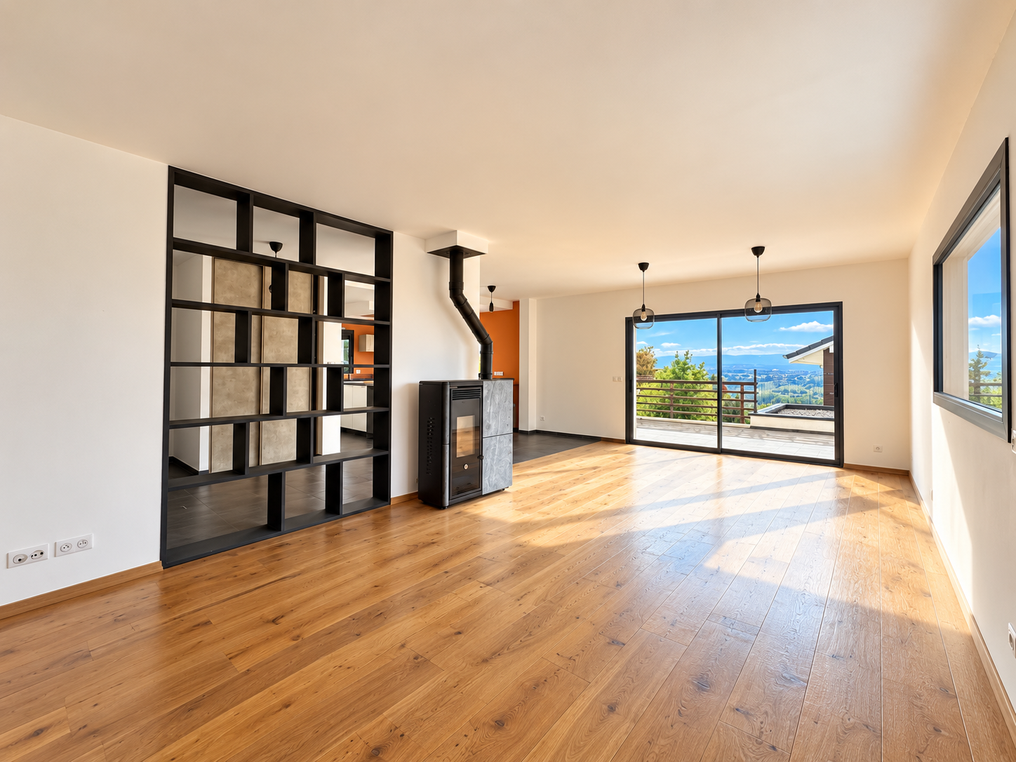 Intérieur d’une maison à Challex Intérieur lumineux d'une maison avec un poêle à bois et vue sur le bassin genevois.