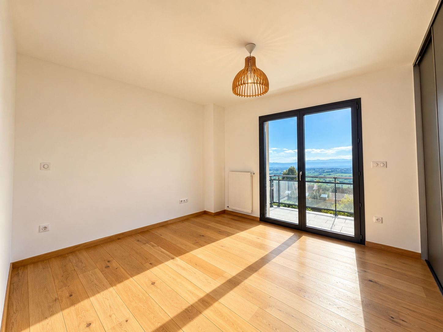 Chambre avec vue à Challex Chambre lumineuse avec parquet et vue sur le paysage, fenêtres ouvertes sur un balcon.