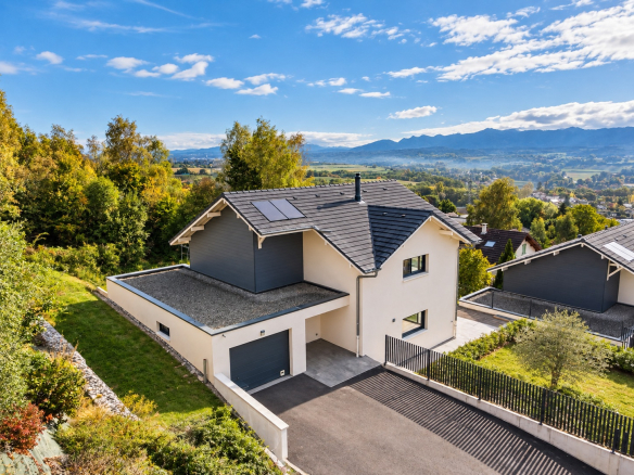 Maison individuelle moderne à Challex, entourée de verdure avec vue sur le bassin genevois.
