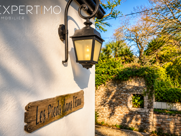 Property facade with lantern and "Feet in the Water" sign in Le Relecq-Kerhuon